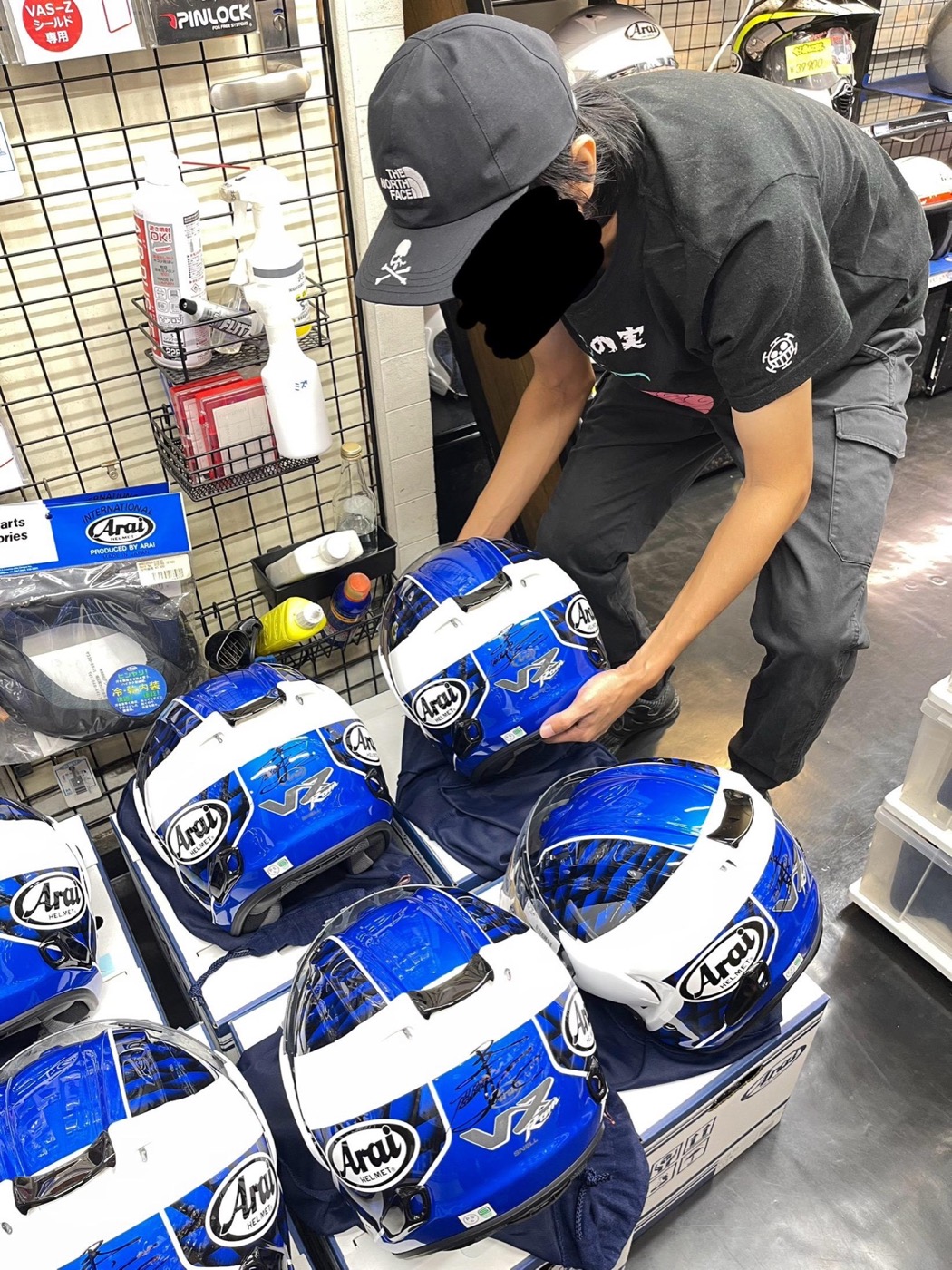 Tuan Arif menyusun helmet Arai di kedai